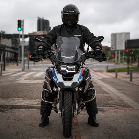 Motociclista en moto con el combo impermeable completo