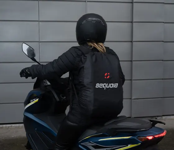 Cubre maleta impermeable puesto sobre el morral de un motociclista